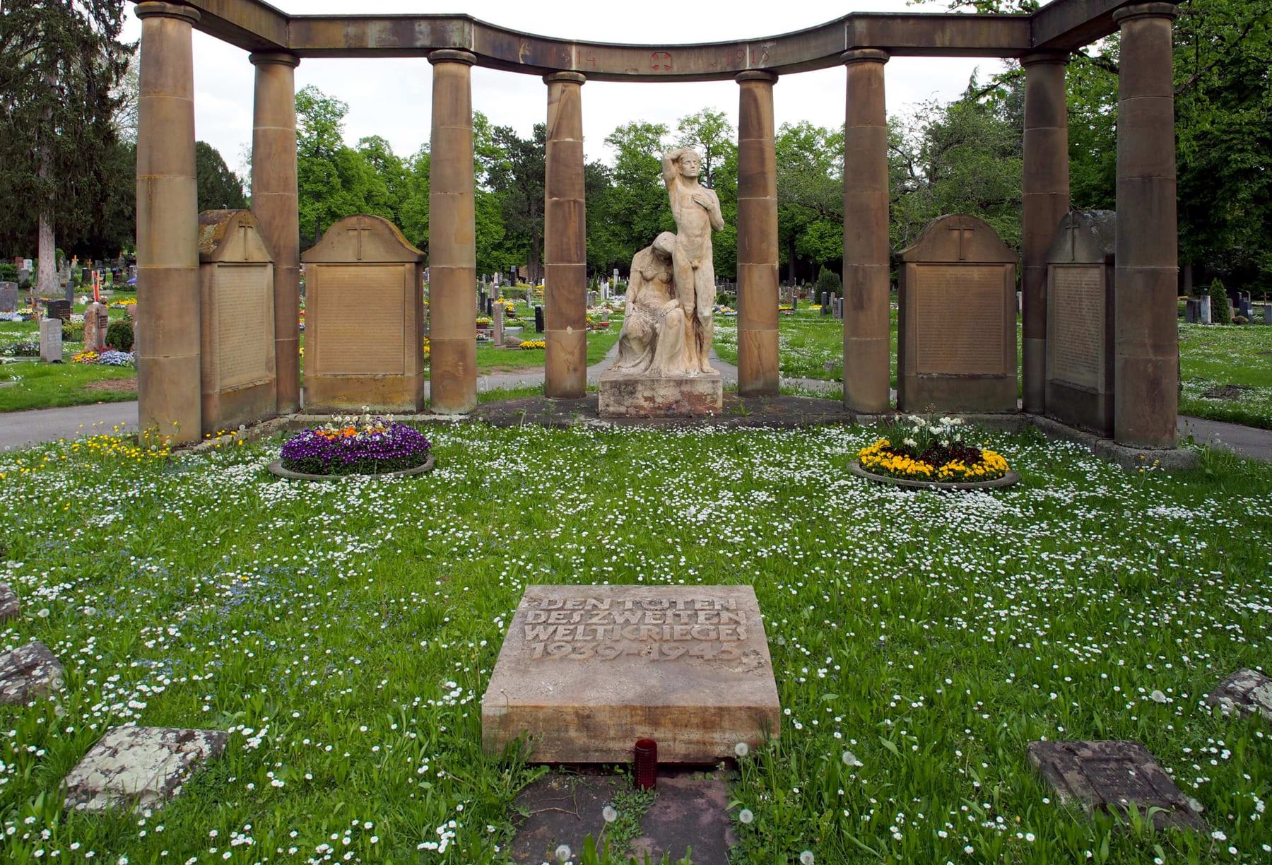 Halbrund gefasstes Denkmal für die Opfer des Zweiten Weltkriegs mit zentraler Trauerfigur auf Friedhof Zuffenhausen